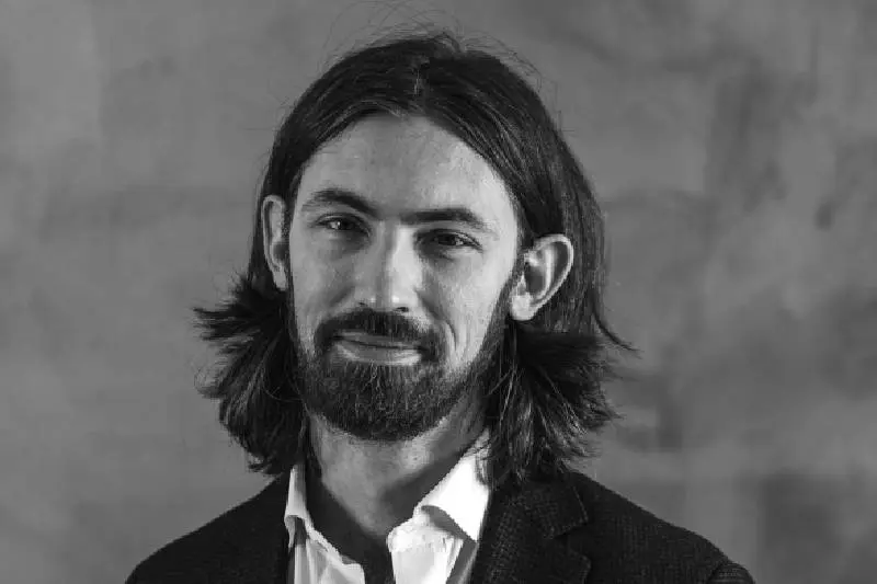 A black and white photo of a man with long hair and beard.